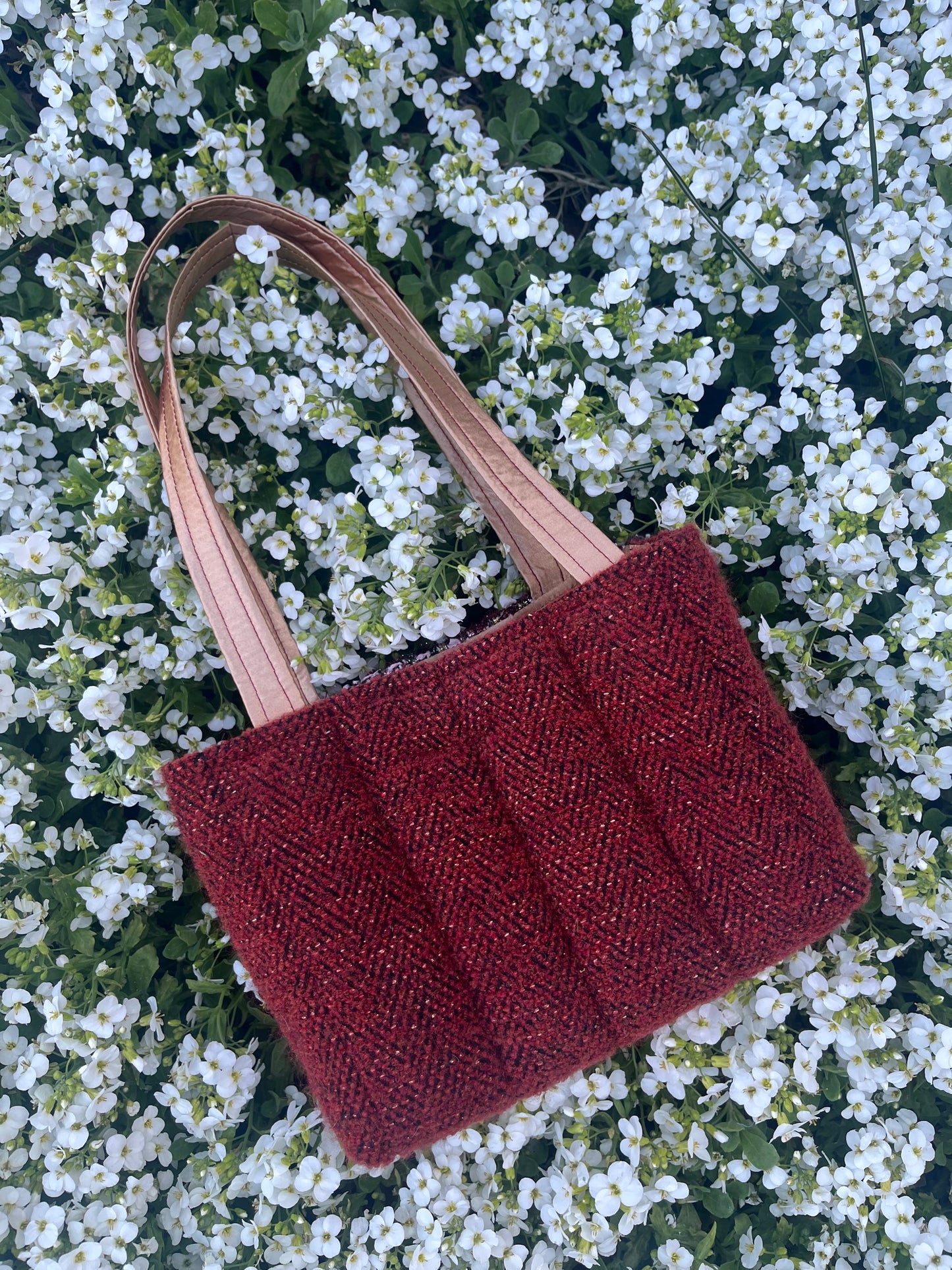 The Craster medium handbag in textured metallic tweed, designed with structured satin handles and sleek metal hardware for a compact yet elegant finish.