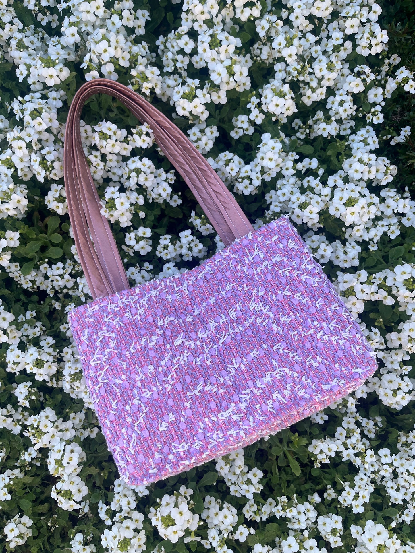 The Amble medium tweed handbag with signature structured satin handles and sleek metal detailing.