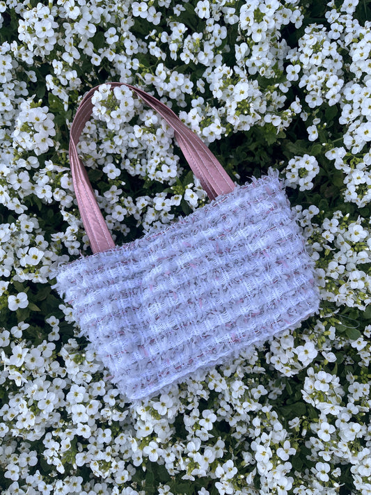 The Newton mini tweed bag, styled with structured satin handles and elegant finishing.