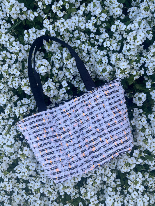The Jesmond medium handbag crafted in traditional tweed with pops of orange, designed with structured satin handles and metal hardware.