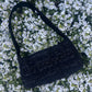 The Cresswell baguette handbag in premium tweed, styled with structured satin handles and polished metal hardware for a chic, compact statement.