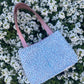 The Amble medium tweed handbag with signature structured satin handles and sleek metal detailing.