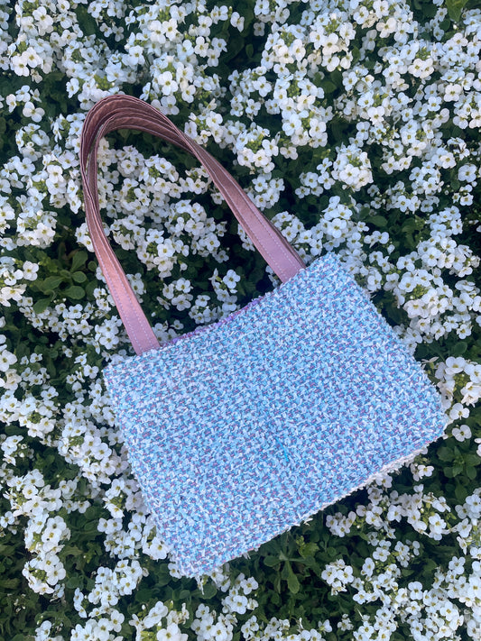 The Amble medium tweed handbag with signature structured satin handles and sleek metal detailing.