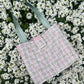 The Corbridge large handbag crafted from heritage tweed, featuring structured satin handles and polished metal hardware for a refined, timeless look.
