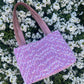 The Amble medium tweed handbag with signature structured satin handles and sleek metal detailing.