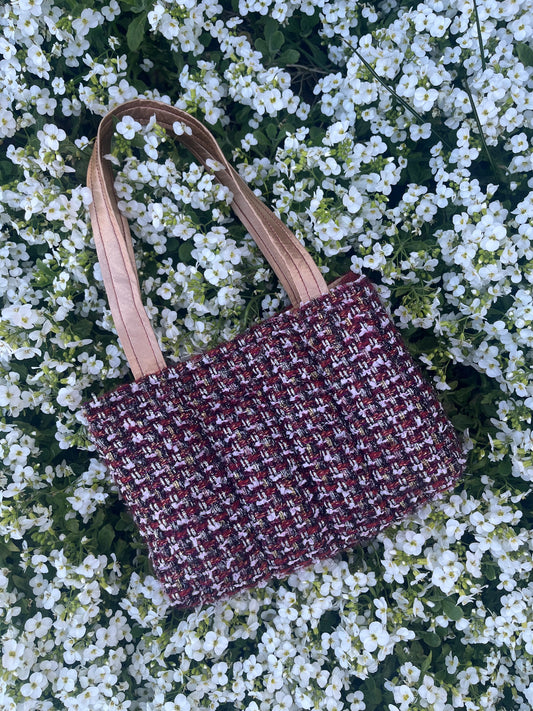 The Craster medium handbag in textured metallic tweed, designed with structured satin handles and sleek metal hardware for a compact yet elegant finish.