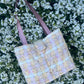 The Ouseburn large-sized tweed handbag, finished with structured satin handles and polished metal hardware for everyday elegance.