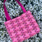 The Alnwick large handbag crafted from sustainable tweed, featuring structured satin handles with polished metal hardware.