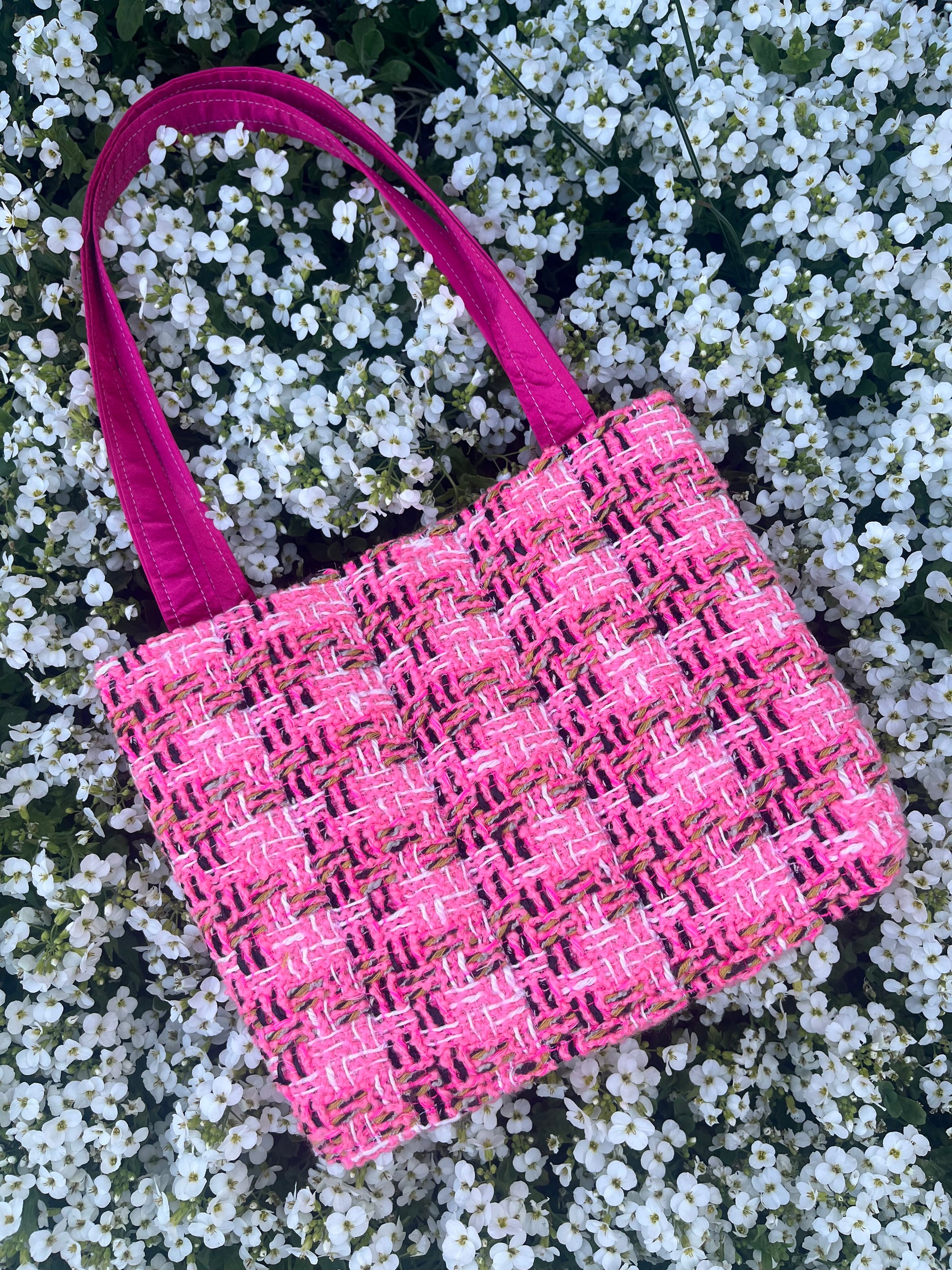 The Alnwick large handbag crafted from sustainable tweed, featuring structured satin handles with polished metal hardware.