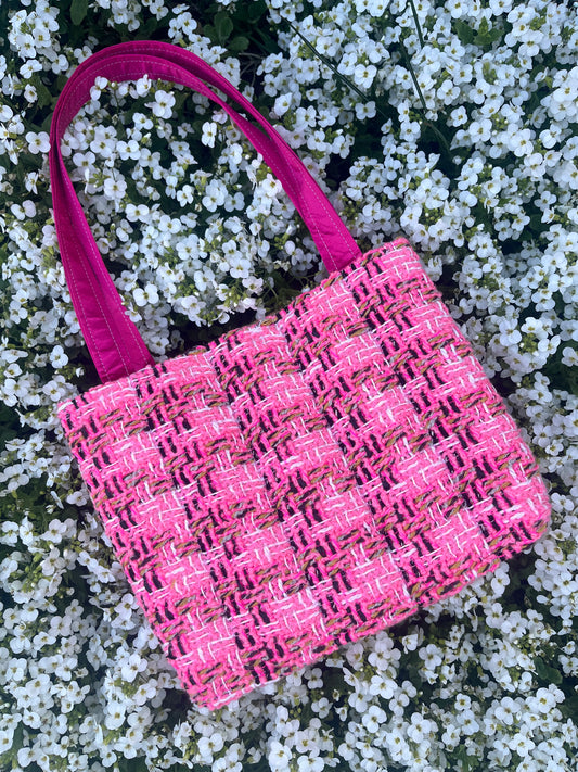 The Alnwick large handbag crafted from sustainable tweed, featuring structured satin handles with polished metal hardware.