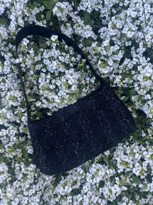 The Cresswell baguette handbag in premium tweed, styled with structured satin handles and polished metal hardware for a chic, compact statement.