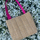 The Alnwick large handbag crafted from sustainable tweed, featuring structured satin handles with polished metal hardware.