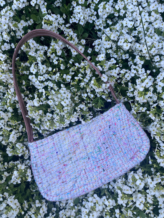 The Alnmouth baguette style handbag in luxurious multi coloured tweed, designed with structured satin handles and polished metal hardware for a refined, statement piece.